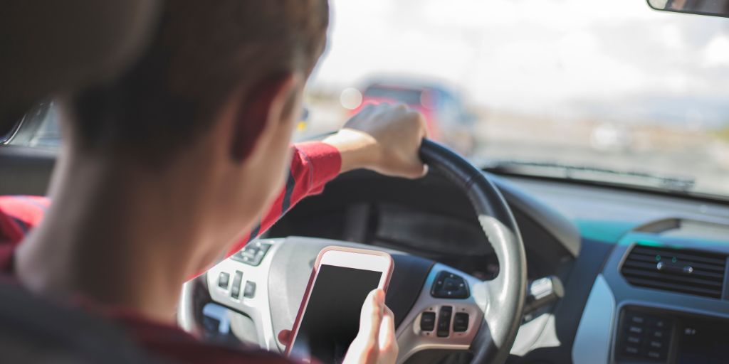Driver using his cell phone on the road