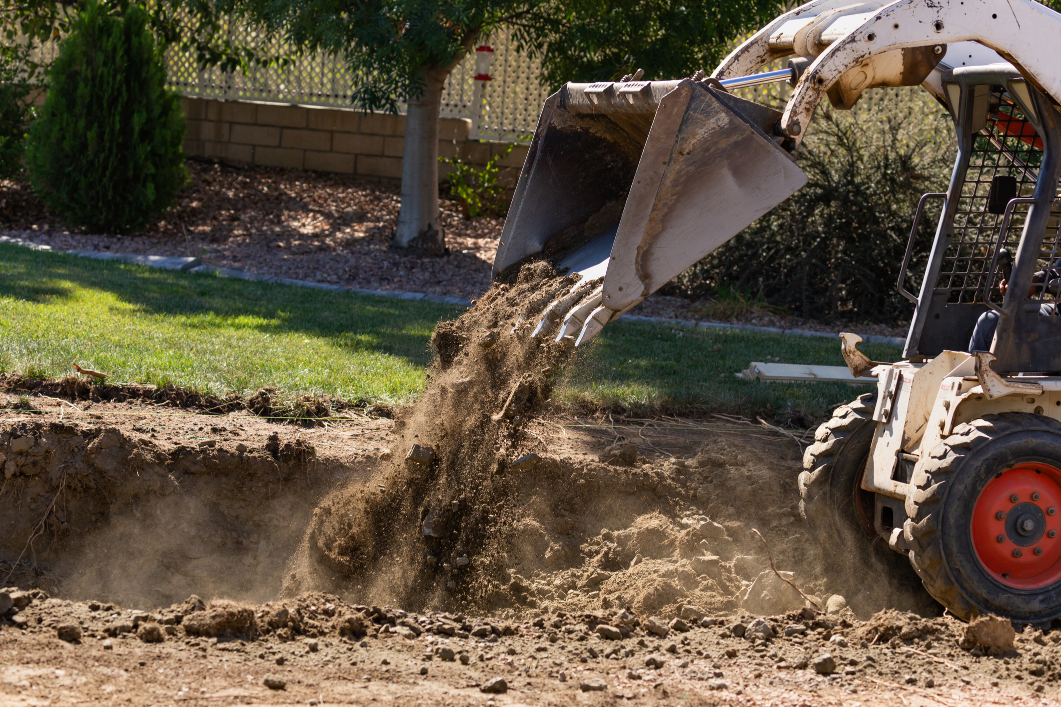 Small Bulldozer Digging In Yard For Service Lines