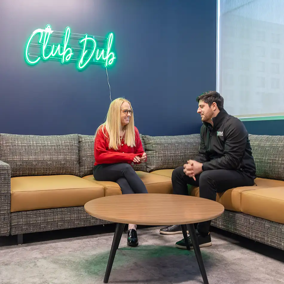 Walsh employees sitting and chatting in "Club Dub" at Walsh's Buffalo office in Larkinville