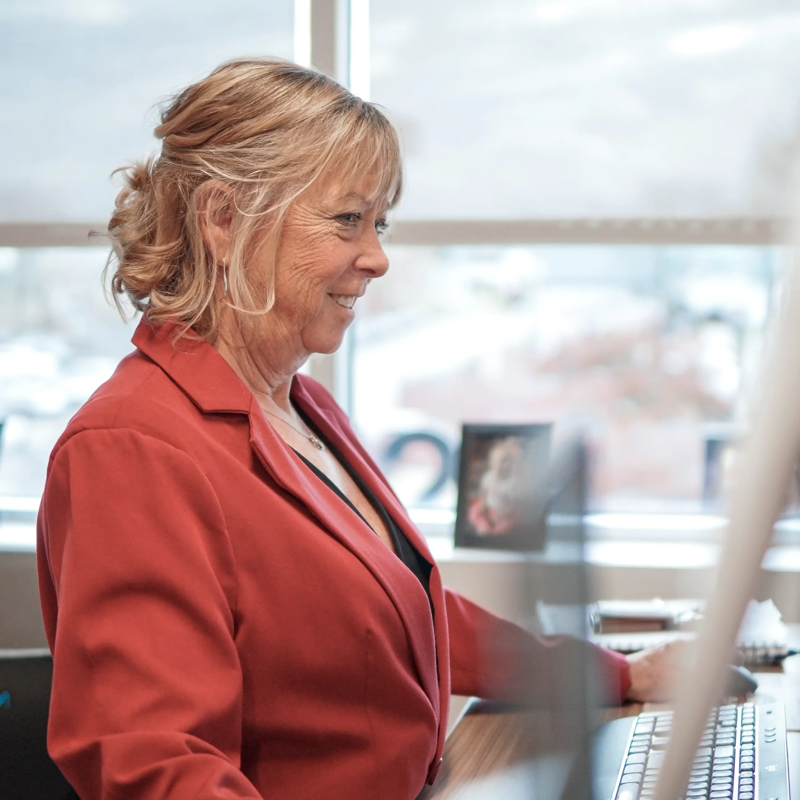 Female Walsh employee standing at her computer, working to find the best rates for her client