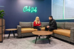 Employees haging out and talking in the "Club Dub" lounge area at the Walsh Buffalo office