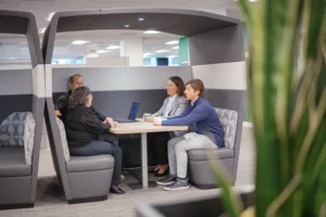 Picture of employees having a discussion in one of the meeting pods at the Walsh Buffalo office