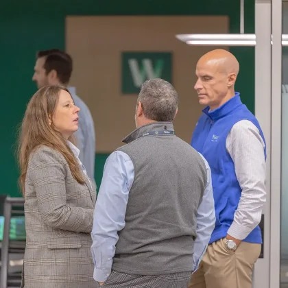 Walsh emplyees discussing client insurance plan needs outside a conference room